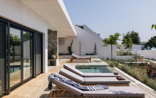 un patio con sedie a sdraio e una piscina di Private pool with prime location Oraio Meros a Paleros