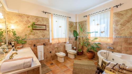 a bathroom with a tub and a toilet and a sink at Villa Cereza Antequera - La Higuera by Ruralidays in Antequera