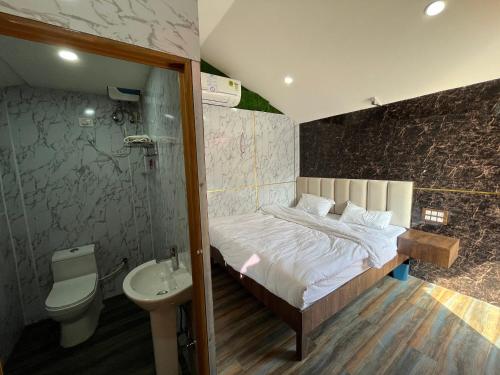 a bedroom with a bed and a toilet and a sink at The Avenue Ranchi in Rānchī