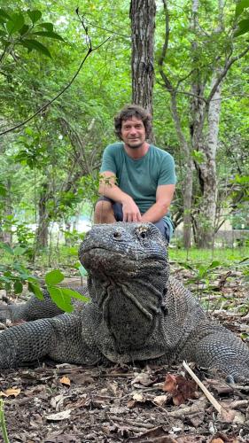 a man sitting on top of a large alligator at Jhuna Komodo Homestay in Komodo