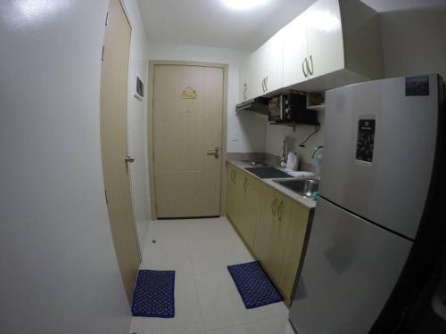uma pequena cozinha com um frigorífico branco e um lavatório em Staycation in the South (Near Manila Airport) em Manila