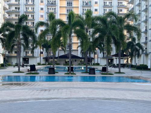 a courtyard with palm trees in front of a building at Staycation in the South (Near Manila Airport) in Manila