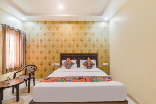 a bedroom with a bed and a desk and a table at FabExpress Grand Inn in Vibhuti Khand