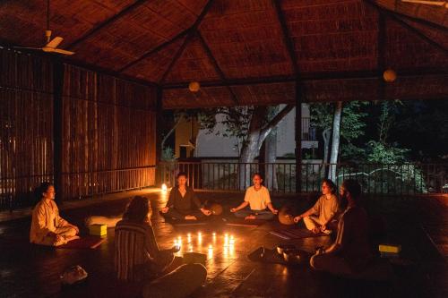 a group of people sitting on the floor with candles at Kasara Chitwan in Chitwan