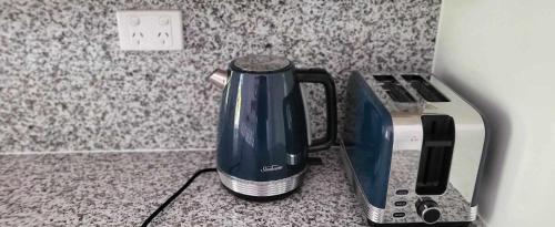 a coffee maker sitting on a counter next to a toaster at Ribbonwood Bed & Breakfast, Emu Park Qld in Emu Park