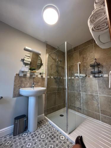 a bathroom with a shower and a sink at Oaklodge House in Leyburn