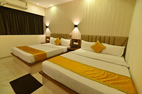 a hotel room with two beds in a room at Aurelia Comforts - Deralakatte in Mangalore