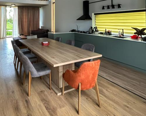 a kitchen with a wooden table and chairs at Villa N40 in Kachretʼi