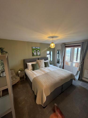 a bedroom with a large bed and a window at Oaklodge House in Leyburn