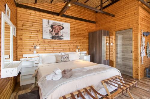 a bedroom with a large bed in a wooden wall at Abendruhe Lodge in Pretoria