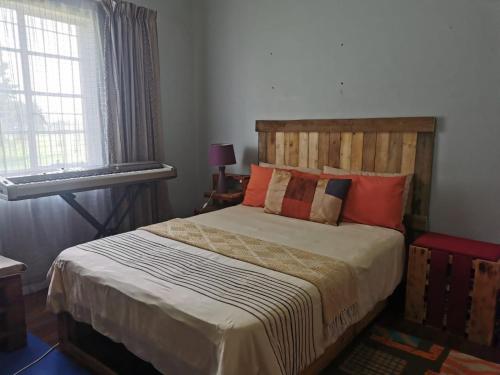 a bedroom with a bed with a wooden headboard at Garden View Home in Brakpan