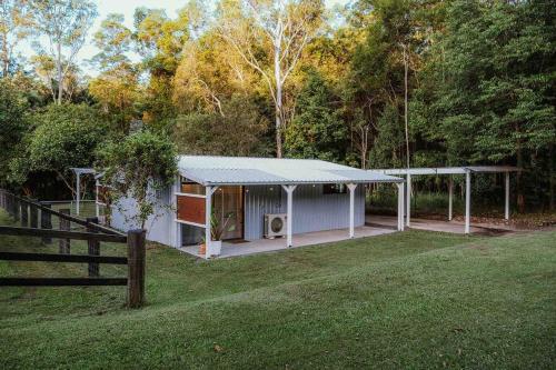 a white house with a fence and a yard at Kookaburra Cottage in North Arm