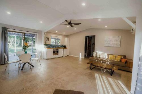 a living room with a couch and a table at Kookaburra Cottage in North Arm