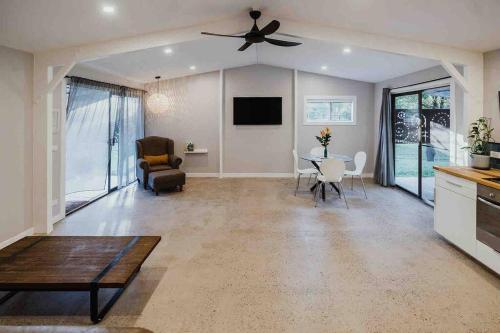 a living room with a ceiling fan and a table at Kookaburra Cottage in North Arm