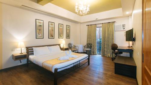 ein Schlafzimmer mit einem Bett und einem Schreibtisch in einem Zimmer in der Unterkunft RedDoorz Premium at Anisabel Suites Davao City in Davao City