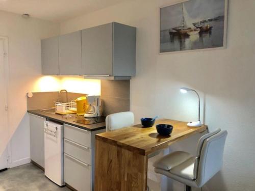 une cuisine avec un comptoir en bois dans une pièce dans l'établissement Studio 303, Héliopolis J au village naturiste, au Cap d'Agde