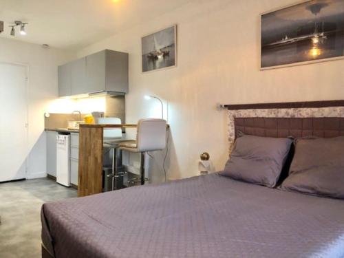 une chambre avec un grand lit et une cuisine dans l'établissement Studio 303, Héliopolis J au village naturiste, au Cap d'Agde