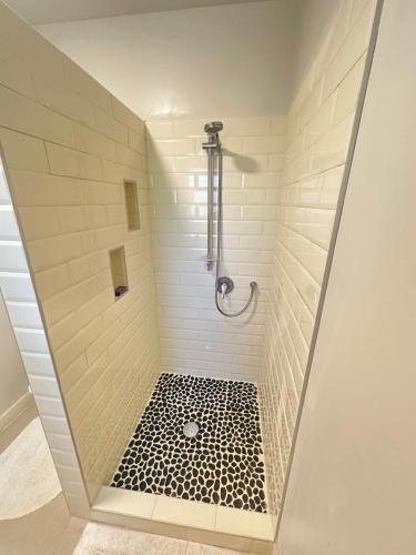 a bathroom with a shower with a black and white floor at Muri Villas in Rarotonga