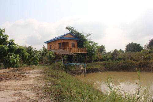 a house on the side of a body of water at Kampot CoCo Homestays in Phumĭ Bœ̆ng Preăh (1)