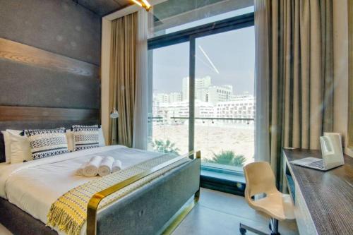 - une chambre avec un lit, un bureau et une grande fenêtre dans l'établissement Fully Equipped Cozy Studio in the heart of JVC, à Dubaï