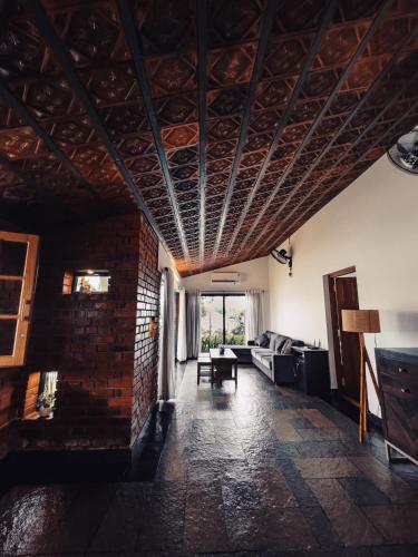 - un salon avec un canapé et un mur en briques dans l'établissement Bamboonest Riverside, à Ernakulam