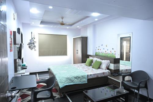1 dormitorio con 1 cama y sillas en Anyhour Stay en Gannavaram