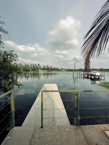 - une vue sur un lac avec un quai dans l'eau dans l'établissement Bamboonest Riverside, à Ernakulam