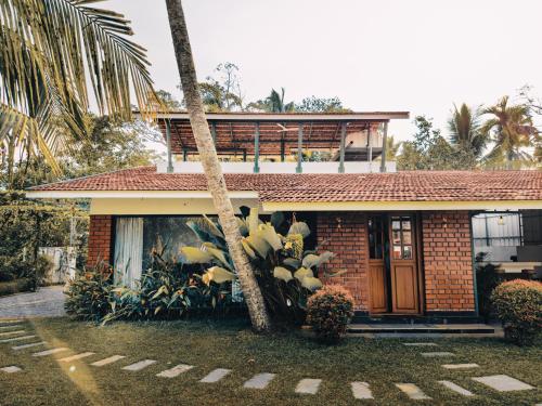 une maison avec un palmier en face dans l'établissement Bamboonest Riverside, à Ernakulam