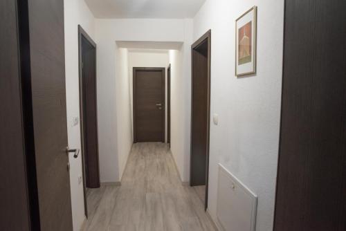 a hallway with white walls and wooden floors and doors at Apartma Katja in Škofja Loka