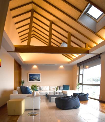 a living room with a ceiling with wooden beams at Ocean View Luxury Beach House - High-end stay beside Ohama Beach! in Shimoda
