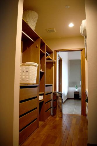 a room with a closet with wooden shelves and a hallway at Ocean View Luxury Beach House - High-end stay beside Ohama Beach! in Shimoda