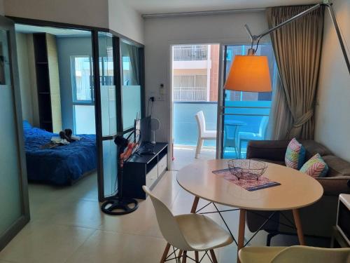 a living room with a table and a couch at Grandblue condominium 205 in Ban Tha Fat