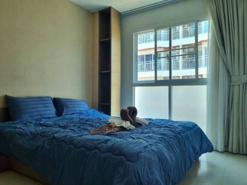 a girl is laying on a bed in a bedroom at Grandblue condominium 205 in Ban Tha Fat