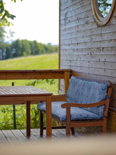 a wooden bench and a table on a porch at Maringotky Na Růžku in Nová Ves
