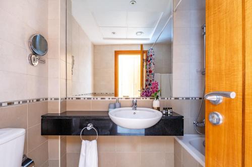 een badkamer met een wastafel en een spiegel bij Frank Porter - Trident Grand in Dubai