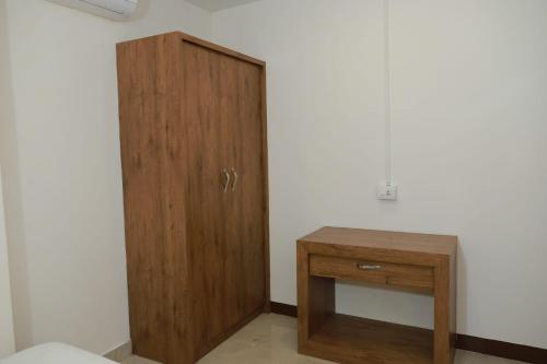 a wooden cabinet and a wooden table in a room at Comfort INN in Payyannūr