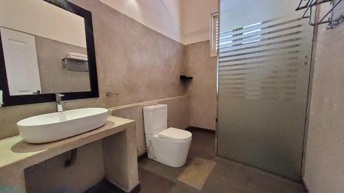 a bathroom with a sink and a toilet and a mirror at Villa Inlet Galle in Galle
