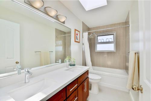 a bathroom with a sink and a toilet and a mirror at Welcome Home in Burnaby