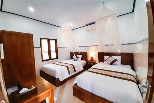 - 2 lits dans une chambre aux murs blancs dans l'établissement Serene Picturesque Villa Near Monkey Forest, à Mambat