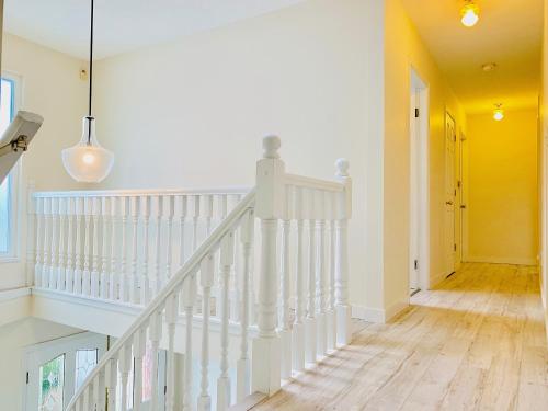 a white staircase in a home with a hallway at Welcome Home in Burnaby