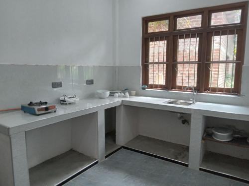 - une cuisine avec un comptoir et un évier dans l'établissement Astral Residence, à Anurâdhapura