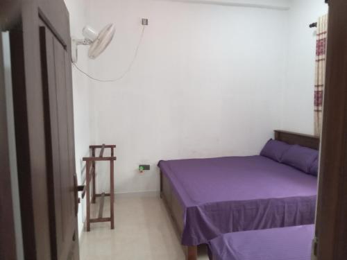 - une petite chambre avec un lit violet et une échelle dans l'établissement Astral Residence, à Anurâdhapura