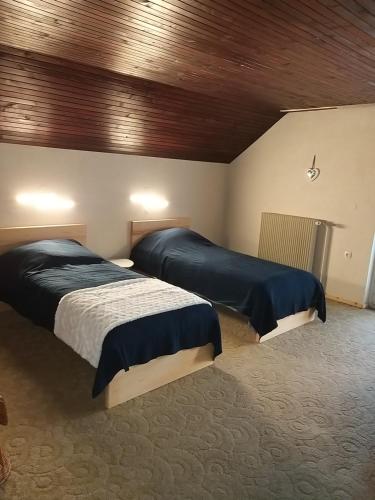 um quarto com 2 camas e um tecto de madeira em Holiday Home NA VASI em Gorenja Vas