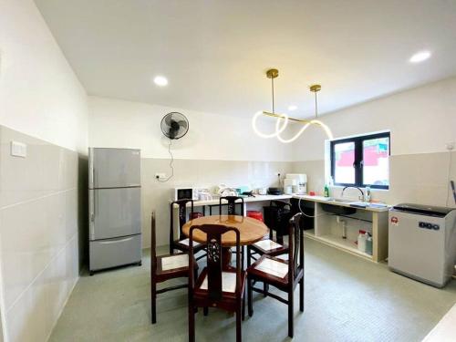 a kitchen with a table and chairs and a refrigerator at Modern Cozy House 4 ROOM 10pax@Bukit Mertajam in Bukit Mertajam
