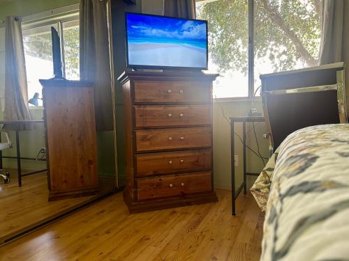 Un dormitorio con un tocador con TV. en Countryside comfort Suite with private bathroom, en Hemet