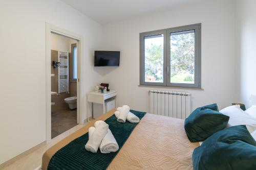 ein Schlafzimmer mit einem Bett mit Handtüchern darauf in der Unterkunft Smilax - Hydruntum Holiday Rooms in Otranto