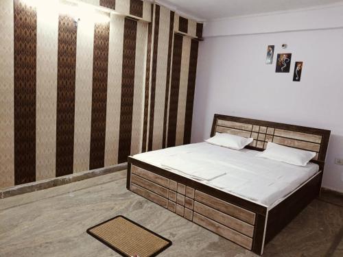 a bedroom with a bed and a wall with stripes at The Urban Heaven in Lucknow