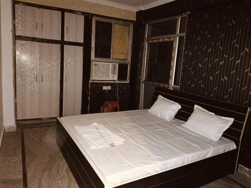 a bedroom with a large bed with white sheets at The Urban Heaven in Lucknow