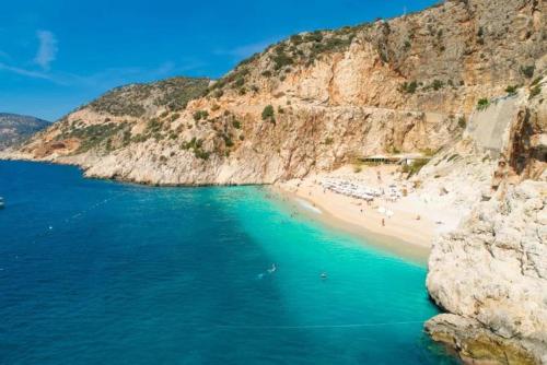 a beach with people on it next to a cliff at Villa Sasha 1 in Ortaca