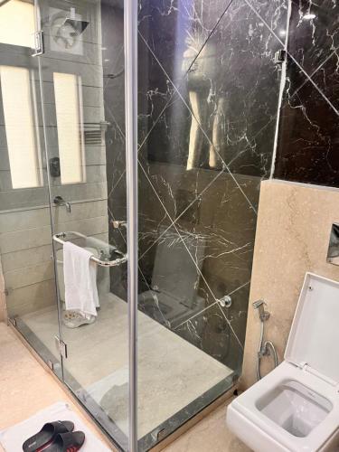 a shower with a glass door in a bathroom at Gazebo Inn & Suites Medanta in Gurgaon